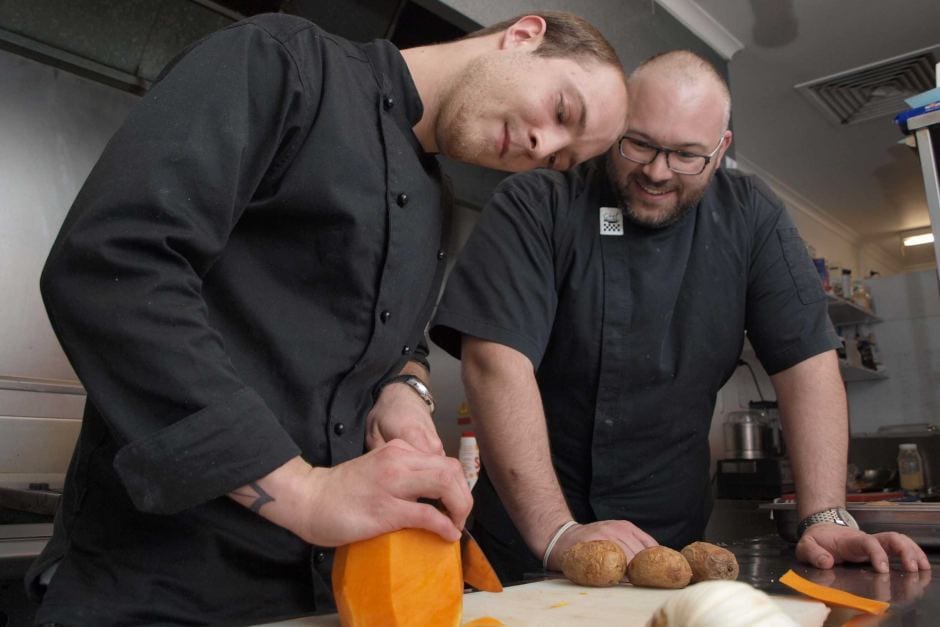 Apprentice chef Alex Kolberg and head chef Kristian Livolsi prep for service in the Taxpayer Restaurants Kitchen in Adelaide